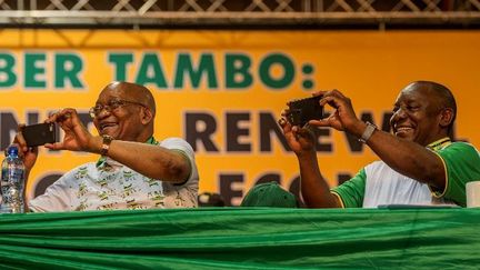 Jacob Zuma (à gauche) et Cyril Ramaphosa photographient avec leur smartphone les participants du congrès de l'ANC en décembre 2017 en Afrique du Sud.  (MUJAHID SAFODIEN / AFP)