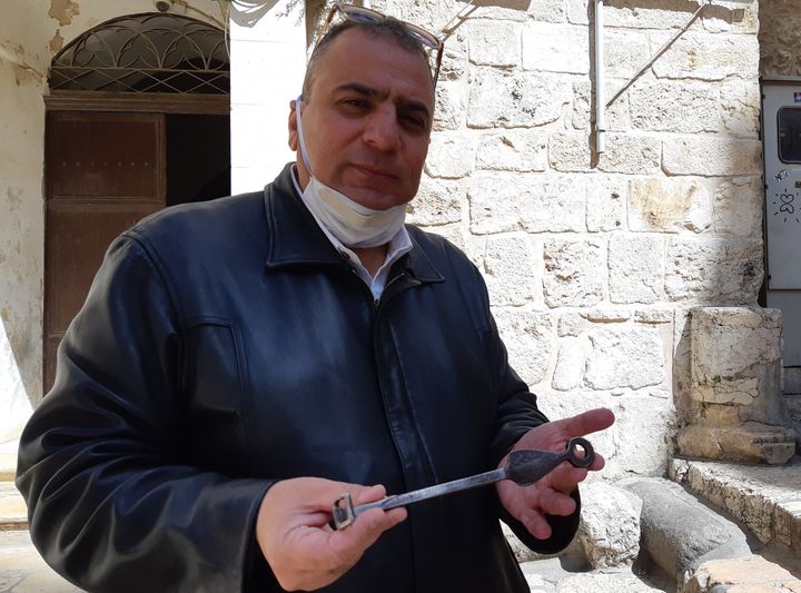 Le gardien du Saint-Sépulcre a fermé l'église. Adeeb Jawad Joudeh Al Husseini, gardien de l'église du Saint-Sépulcre, masque sanitaire sur le menton, montre la clef du lieu de culte. (FRÉDÉRIC MÉTÉZEAU / RADIO FRANCE)