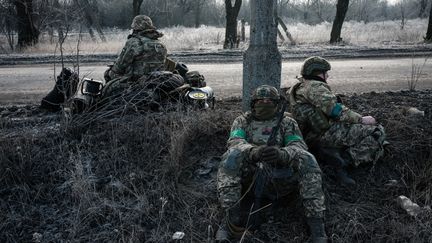 Des parachutistes ukrainiens attendent un transport le long de la route à Chasiv Yar, dans l'est du pays, le 28 janvier 2023. (YASUYOSHI CHIBA / AFP)