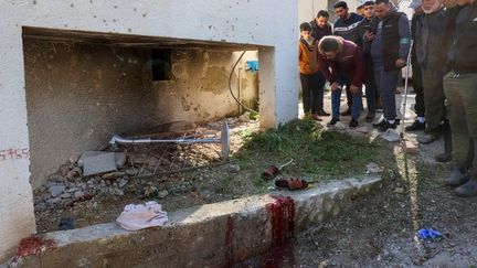 Des Palestiniens se réunissent sur le site d'une frappe israélienne qui a fait trois morts, dont deux enfants, à Tammoun, en Cisjordanie occupée, le 8 janvier 2024. (ZAIN JAAFAR / AFP)