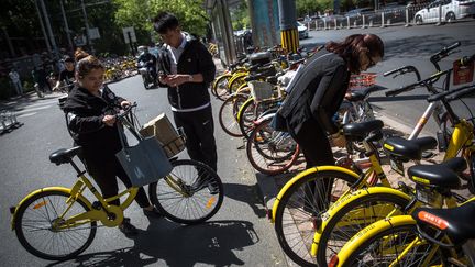 Utilisateurs de vélos partagés Mobike à Pékin, en Chine. (ROMAN PILIPEY / EPA)