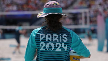 Une volontaire, engagée sur les Jeux olympiques de Paris 2024, sur le tournoi masculin de beach-volley, le dimanche 4 août 2024, au pied de la Tour Eiffel à Paris. (THOMAS SAMSON / AFP)