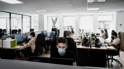 Des personnes portent des masques sur leur lieu de travail dans une&nbsp; entreprise lyonnaise, le 1er septembre 2020 à Lyon, le premier jour où ils sont devenus&nbsp;obligatoires dans les entreprises. (JEFF PACHOUD / AFP)