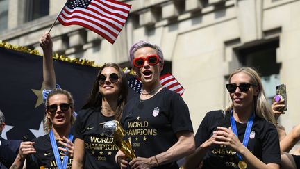 Megan Rapinoe, capitaine de l'équipe de football américaine, entourée d'autres joueuses, lors de leur célébration de championnes du monde le 10 juillet 2019 à New York (Etats-Unis).&nbsp; (JOHANNES EISELE / AFP)