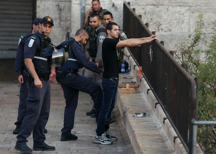 Des policiers isra&eacute;liens contr&ocirc;lent un homme dans J&eacute;rusalem-Est, mardi 13 octobre 2015. (AHMAD GHARABLI / AFP)