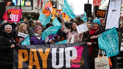 Des enseignants tiennent des pancartes lors d'une manifestation, le 1er février 2023. Photo d'illustration. (ADRIAN DENNIS / AFP)