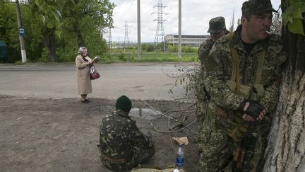 Une femme lit la Bible dans une rue de Sloviansk occup&eacute;e par les pro-russes, le 5 mai 2014.&nbsp; (BAZ RATNER / REUTERS)