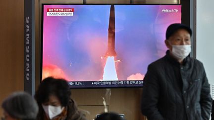 Des personnes regardent des images&nbsp;d'archives d'un essai de missile nord-coréen, dans une gare de Séoul (Corée du Sud), le 2 novembre 2022.&nbsp; (JUNG YEON-JE / AFP)