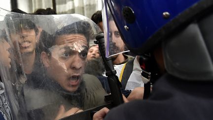 Des étudiants face aux forces de sécurité lors d'une manifestation à Alger, &nbsp;le 26 février 2019, contre la candidature du président Abdelaziz Bouteflika pour un cinquième mandat. (RYAD KRAMDI / AFP)