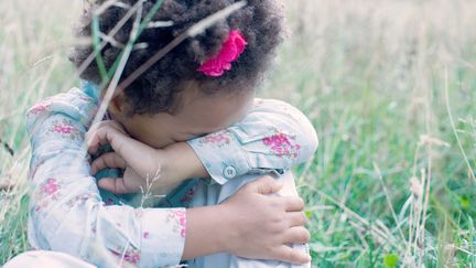 Une petite fille se cache pour pleurer. (ANNE-SOPHIE BOST
 / MAXPPP)