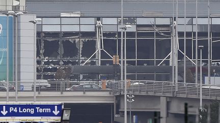 Les fenêtres brisées de la façade de l'aéroport de Bruxelles, à Zaventem, après deux explosions dans le terminal principal, mardi 22 mars 2016. (JOHN THYS / AFP)