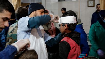 Des blessés pris en charge après des bombardements du régime syrien dans&nbsp;l'enclave rebelle de la Ghouta orientale près de Damas, en&nbsp;Syrie, le 19 février 2018. (AMMAR AL BUSHY / ANADOLU AGENCY / AFP)