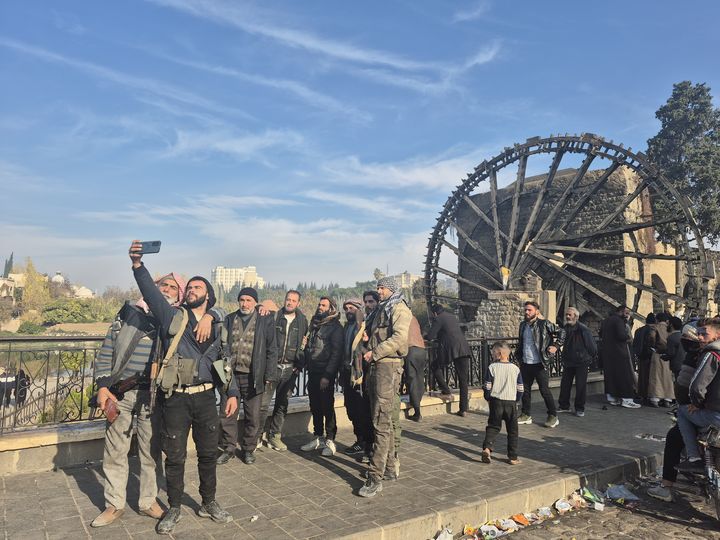 Sur la route d'Alep, à Hama, les habitants se pressent pour se prendre en photo avec les rebelles, le 12 décembre 2024. (MARIE-PIERRE VEROT / RADIO FRANCE)