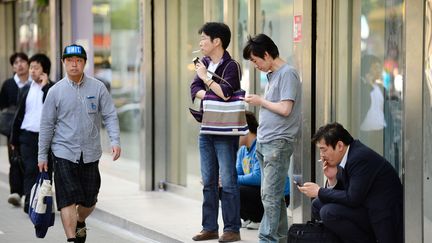 Des fumeurs dans une rue de Tokyo, au Japon, le 31 mai 2013.&nbsp; (TORU YAMANAKA / AFP)