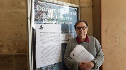 Un des membres de l'équipe pastorale devant l'église&nbsp;Saint-Merry à Paris&nbsp;prêt à distribuer l'appel en faveur d'un vote Macron à la présidentielle, pour contrer le Front national. (RADIO FRANCE / VALENTINE JOUBIN)