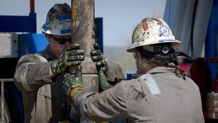 Des employ&eacute;s de Consol Energy remplacent une pi&egrave;ce sur une plate-forme de forage exploitant du gaz de schiste &agrave; Waynesburg, en Pennsylvanie (Etats-Unis), en avril 2012. (MLADEN ANTONOV / AFP)