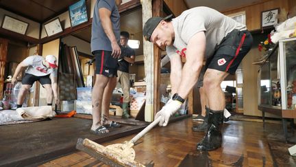 Des joueurs de rugby canadiens aident au nettoyage de la ville de&nbsp;Kamaishi (Japon) après le passage du typhon&nbsp;Hagibis, le 13 octobre 2019. (KYODO KYODO / REUTERS)