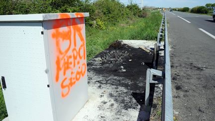 Les restes d'un portique &eacute;cotaxe incendi&eacute; sur la RN11 &agrave; hauteur d'Epannes (Deux-S&egrave;vres), le 10 avril 2014. (XAVIER LEOTY / AFP)