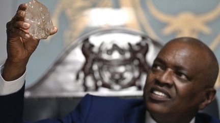 Le président du Botswana, Mokgweetsi Masisi tient un diamant découvert dans son pays, le 22 août 2024. (MONIRUL BHUIYAN / AFP)