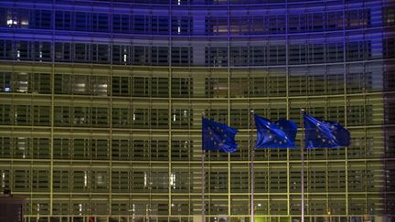 La façade de la Commission européenne, à Bruxelles (Belgique), aux couleurs du drapeau de l'Ukraine, le 24 février 2022. (NICOLAS MAETERLINCK / BELGA MAG / AFP)