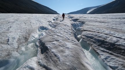 Un randonneur sur un glacier, dans l'archipel du Svalbard (Norvège), en train de fondre sous l'effet des fortes chaleur, le&nbsp; 21 juillet 2020.&nbsp; (SEAN GALLUP / GETTY IMAGES EUROPE)