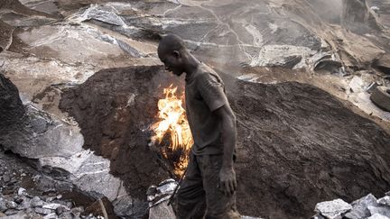 Le caoutchouc mélangé à de la ferraille est alors brûlé pendant des jours pour ainsi fragiliser la pierre et pouvoir la casser plus facilement. (JOHN WESSELS / AFP)