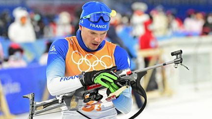 Le biathlète français Emilien Jacquelin lutte avec ses balles de pioche lors du relais mixte 4x6 km, théâtre de la première médaille tricolore des JO de Pékin. (TOBIAS SCHWARZ / AFP)