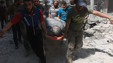 Un homme est pris en charge par les secours après des frappes aériennes de l'armée russe, dans le quartier de Sukkeri, le 28 avril 2016. (BEHA EL HALEBI / ANADOLU AGENCY)