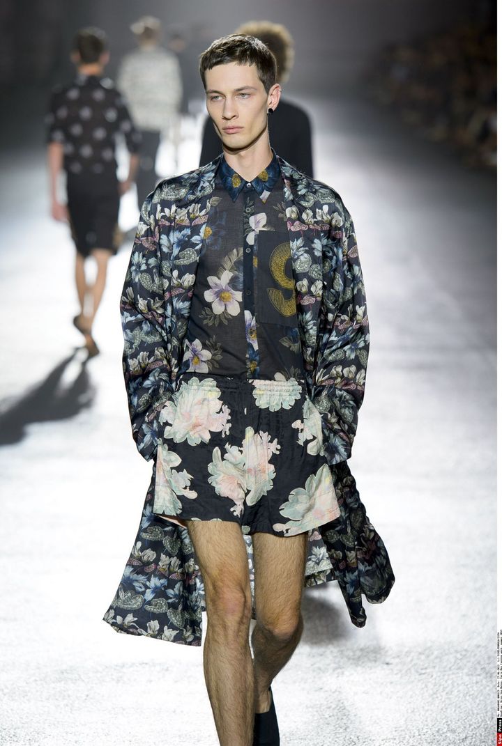 Le Belge Dries Van Noten a des rêves bucoliques. Les fleurs sont quasiment dans toutes ses silhouettes. Un mannequin défile en bermuda marine avec de grosses fleurs jaunes; d'autres, rose pâle, décorent une chemise bleu foncée légèrement transparente. Un imperméable sombre avec des fleurs bleu et vert foncé termine une silhouette. Les manteaux de demi-saison sont ceinturés à la taille. Le créateur a dessiné des vestes militaires. Le vestiaire est globalement sombre mais des touches de couleur (notamment moutarde) apparaissent parfois. Les Arts Décoratifs présentent en 2014, l’exposition Dries Van Noten. Pour ce projet, dans lequel le créateur met en scène son univers, il a été invité à découvrir les réserves et les collections des musées. Certains motifs de textiles du XIXe siècle l’ayant séduit, il les a reproduits pour cette collection estivale.
 ( PIXELFORMULA/SIPA)