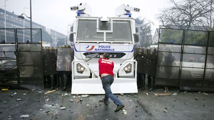 Un salari&eacute; de l'usine Goodyear affronte les forces de l'ordre devant le si&egrave;ge de la marque &agrave; Rueil-Malmaison (Haus-de-Seine), le 7 mars 2013. (LIONEL BONAVENTURE / AFP)