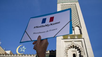 Un homme brandit une pancarte "#NotInMyName" pendant un rassemblement en hommage &agrave; Herv&eacute; Gourdel, devant la Grande mosqu&eacute;e de Paris, le 26 septembre 2014. (JOEL SAGET / AFP)