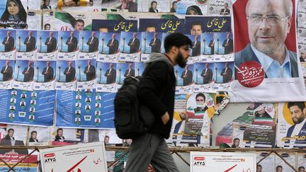 Un homme devant des affiches de campagne, quelques jours avant les élections législatives iraniennes du 1er mars 2024, à Téhéran. (FATEMEH BAHRAMI / ANADOLU)