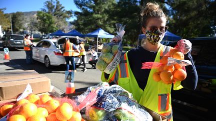 En Californie, aux États-Unis, des bénévoles participent à une distribution de denrées alimentaires pour les plus démunis. (ROBYN BECK / AFP)