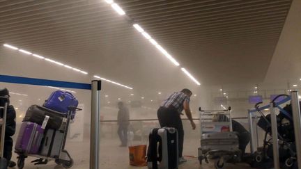 Le terminal de l'aéroport de Bruxelles dans la fumée après deux explosions, mardi 22 mars 2016. (RALPH USBECK / AP / SIPA)