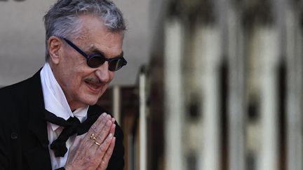 Du haut des marches, le réalisateur Wim Wenders salue la foule et les photographes à la manière des Japonais, mains jointes et courbettes. (VALERY HACHE / AFP)