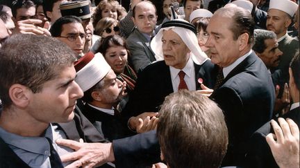 Le président de la République Jacques Chirac pousse un garde israélien alors qu'il proteste contre l'imposant dispositif de sécurité qui l'entoure, le 22 octobre 1996, lors de sa visite dans la vieille ville de Jérusalem. (JIM HOLLANDER / AFP)