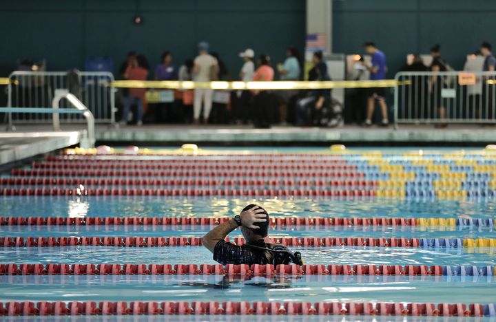 Un plongeur regarde la longue file d'attente pour aller voter dans cette piscine de Los Angeles, le 8 novembre 2016. (JAE C. HONG / AP / SIPA)