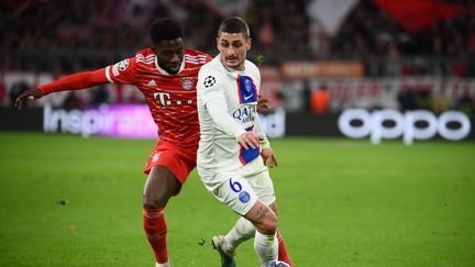 Marco Verratti devant Alphonso Davies lors du huitième de finale retour de la Ligue des champions entre le Bayern Munich et le Paris Saint-Germain à l'Allianz Arena, le 8 mars 2023. (FRANCK FIFE / AFP)