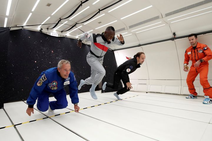 L'athlète Usain Bolt, en compagnie de l'astronaute français Jean-François Clervoy et du designer Octave de Gaulle, lors d'un vol en apesanteur à bord de l'avion Zero G, au-dessus de Reims (Marne), visant à promouvoir un champagne conçu pour l'espace, le 12 septembre 2018.&nbsp; (BENOIT TESSIER / REUTERS)