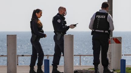 Des policiers sur le bord de mer, à Nice (Alpes-Maritimes), le 20 mars 2020. (ARI? BOTBOL / HANS LUCAS)