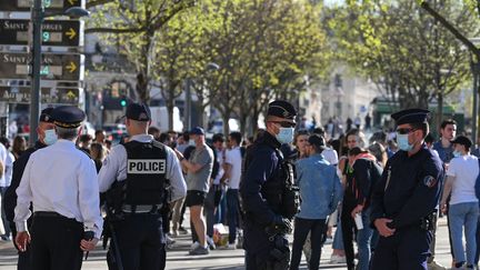 Des policiers français évacuent des personnes rassemblées dans une rue de Lyon, le 31 mars 2021. (PHILIPPE DESMAZES / AFP)