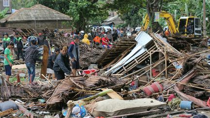 Des habitants de Carita (Indonésie) inspectent des maisons balayées par le tsunami, le 23 décembre 2018. (AP / SIPA)