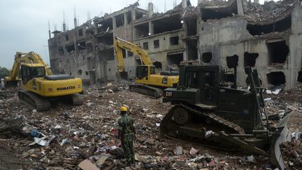 Des militaires continuent de fouiller, le 12 mai 2013,&nbsp;les d&eacute;combres de l'usine de Savar (Bangladesh), dont l'effondrement le 24 avril a fait 1 127 morts. (AFP)