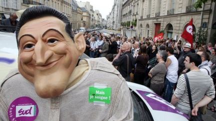 Un manifestant portant une camisole et un masque à l'éffigie du président Sarkozy, le 10 mai 2011, devant le Sénat. (AFP)