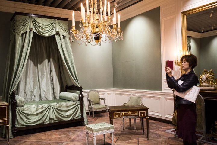 Une visiteuse photographie une partie de la chambre reconstituée de Marie-Antoinette à l'exposition "Marie-Antoinette, une reine à Versailles" au Mori Arts Center  Gallery, à Tokyo, en octobre 2016
 (BEHROUZ MEHRI / AFP)