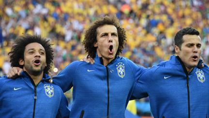 Marcelo (&agrave; gauche), David Luiz (centre) et Julio Cesar (droite) chantent l'hymne br&eacute;silien avant le match contre la Croatie, le 12 juin 2014 &agrave; Sao Paulo (Br&eacute;sil). (VANDERLEI ALMEIDA / AFP)