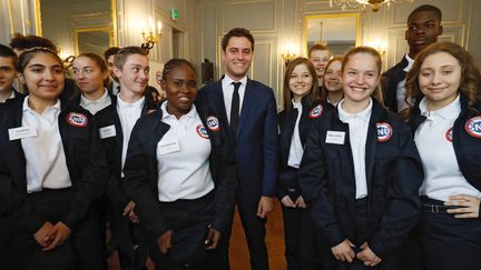 De jeunes volontaires du "service national universel" entourent le secrétaire d'Etat chargé de la jeunesse, Gabriel Attal. (FRANCOIS GUILLOT / AFP)