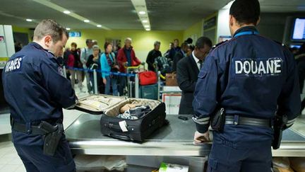 &nbsp; (Les douaniers de l'aéroport de Roissy, au nord de Paris, contrôlent le contenu de bagages suspects © Maxppp)