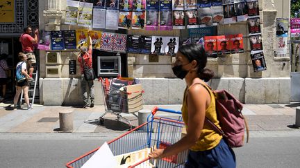 Des personnes accrochent des affiches de pièces de théâtre pour le festival d'Avignon, le 5 juillet 2021. Photo d'illustration. (NICOLAS TUCAT / AFP)