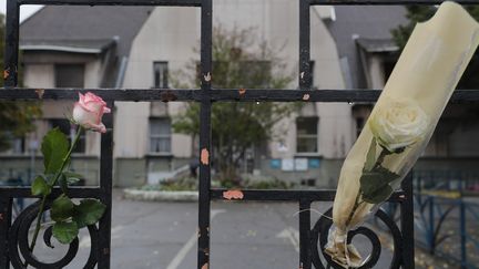 Des roses accrochées à la grille de l'école de Pantin le 5 octobre 2019 lors d'une marche en hommage à la directrice de l'établissement, Christine Renon, après son suicide. (GEOFFROY VAN DER HASSELT / AFP)